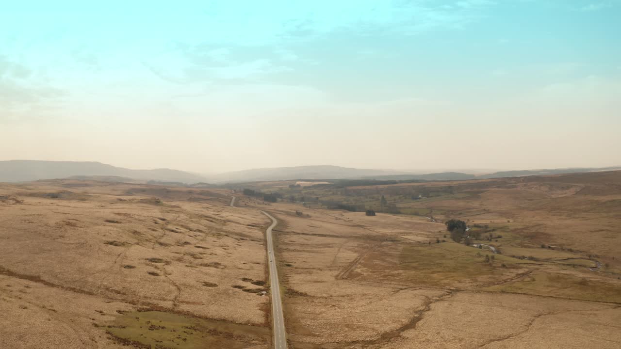vista aérea de la carretera rural con coches en el campo seco, gales, reino unido
