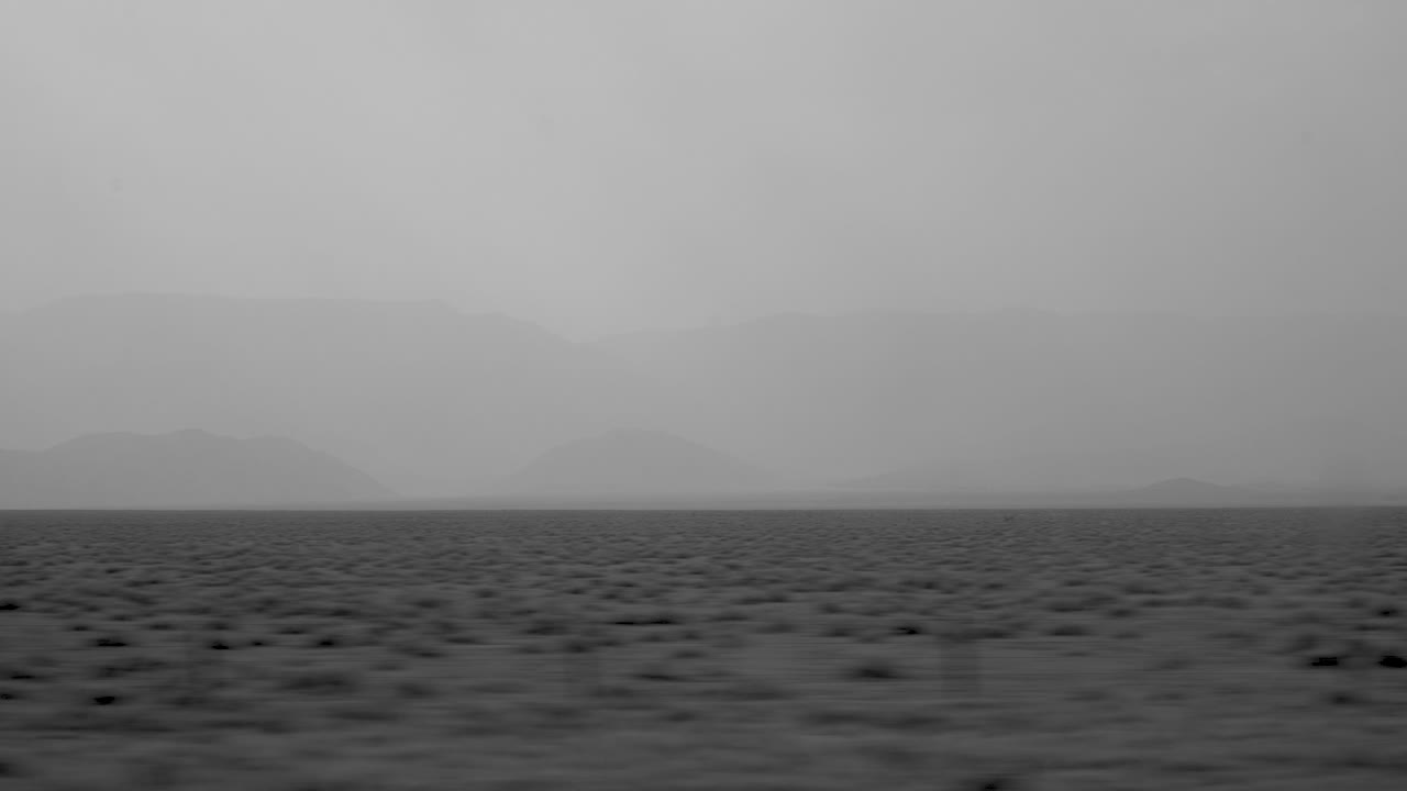 Black and white shot of mist and ash floating over a mountain range in Wyoming, United States.