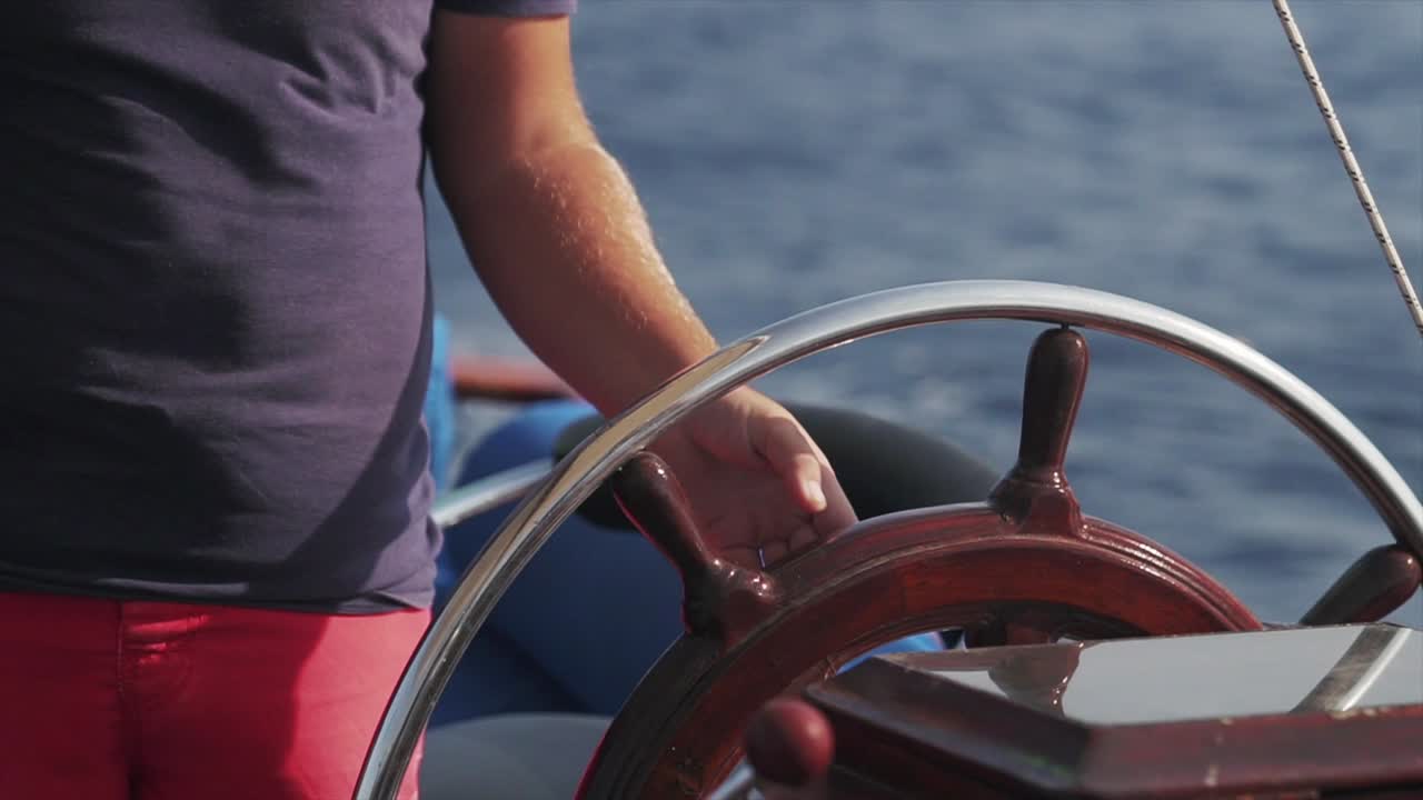 A close up shot of a skipper steering a ship at sea