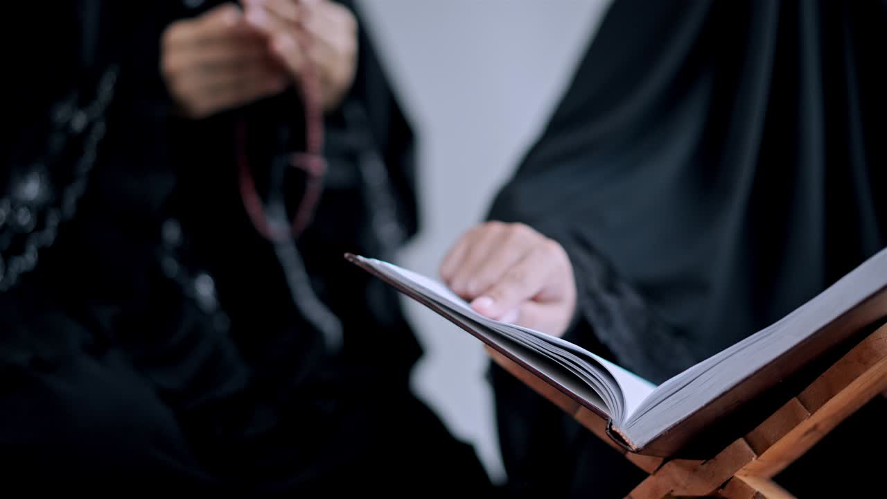 쿠란을 읽는 동안 젊은 무슬림 여성의 손을 가까이 들고