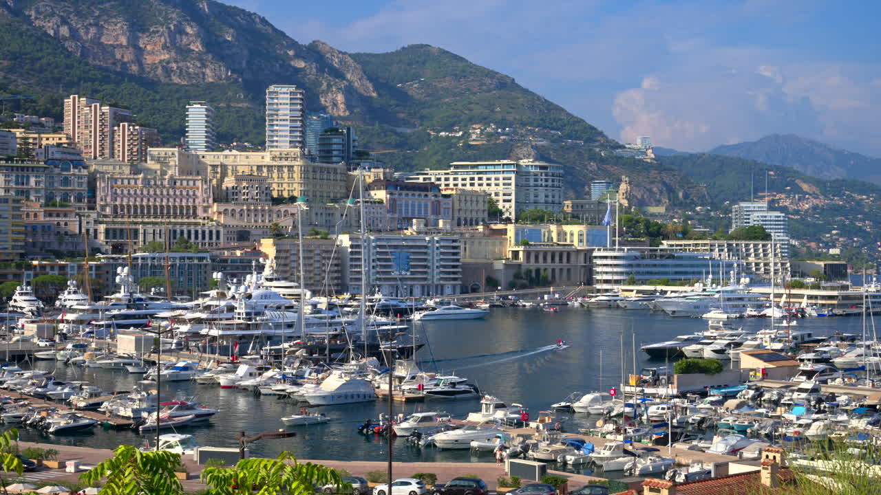 View of boats docked in the Monaco Marina with the skyline of the city on the background