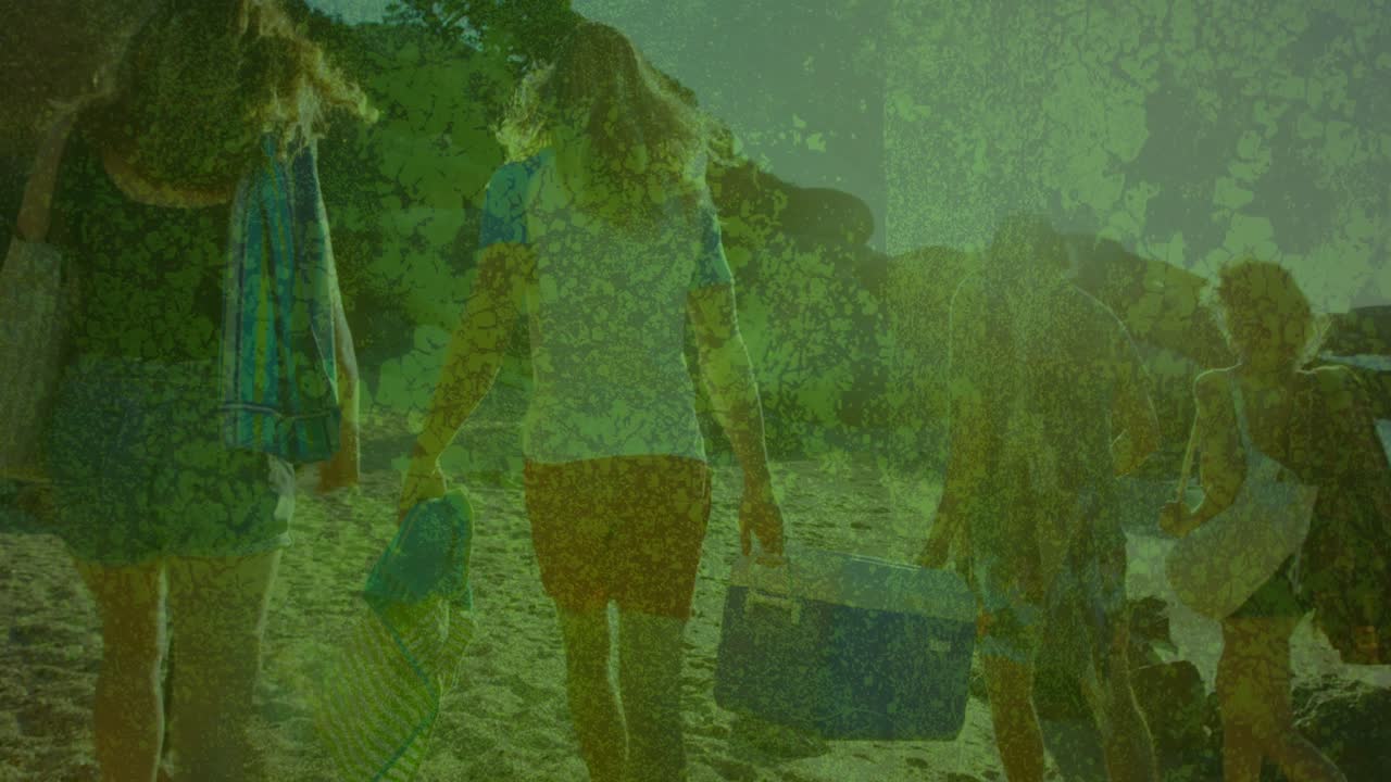 La telecamera segue cinque amici che camminano verso l'acqua con un frigo portatile, con una sovrapposizione verde a tema viaggio che maschera i dettagli