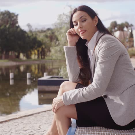 Gorgeous-business-woman-sitting-on-bench