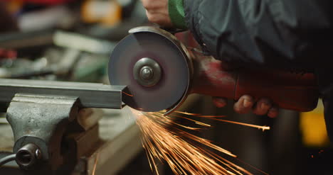 steel industry man using angle grinder grinding metal object