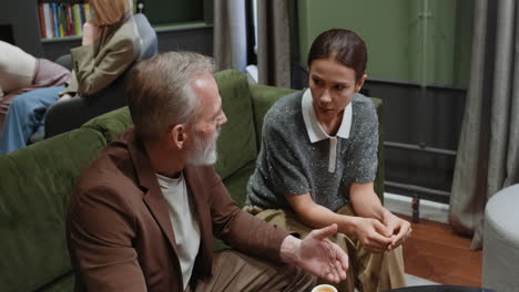 two people engaged in a conversation over coffee in a lounge setting