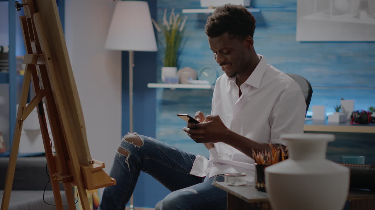 Black drawing artist using smartphone for fine art pictures