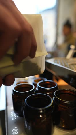 pouring coffee beans into jars