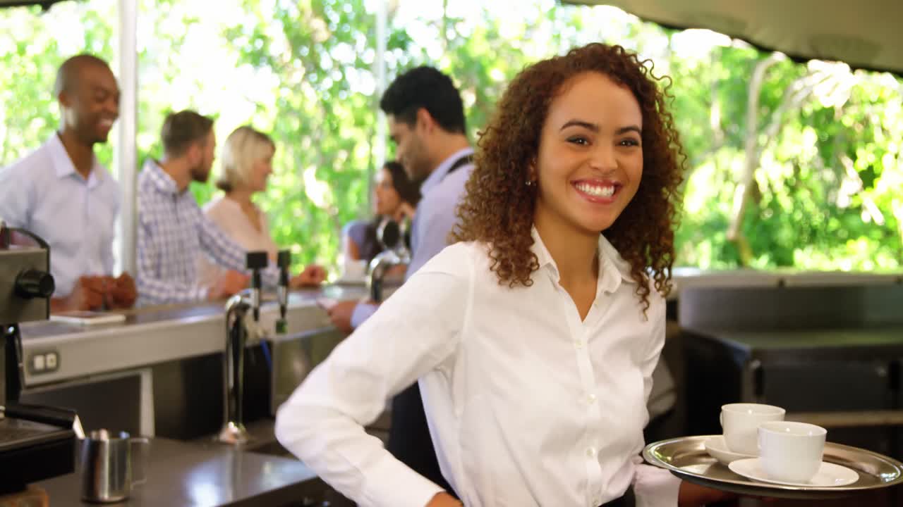 Female waitress serving coffee to customers