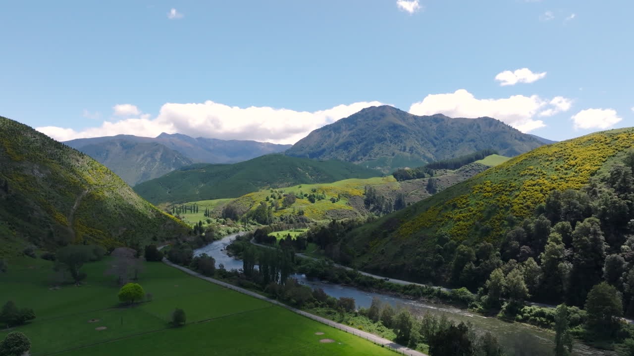 Breathtaking aerial drone shot soaring down the valley over the winding Motueka River in New Zealand on a bright sunny day