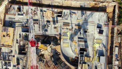 vuelo aéreo sobre un sitio de desarrollo de nuevas construcciones con grúas de torre alta que construyen bienes raíces