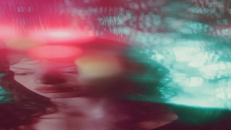 Portrait of Young Pensive Woman under Red and Blue Glowing Lights