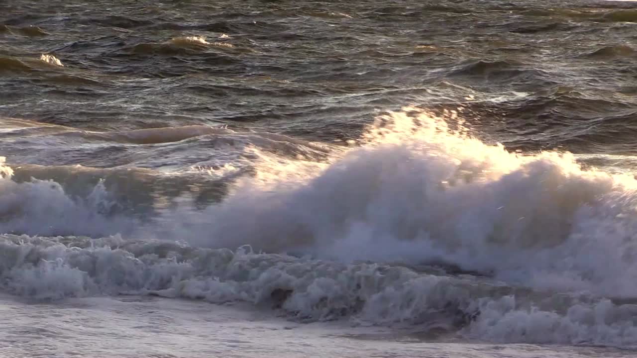 Potenti onde oceaniche che si infrangono con schiuma bianca lungo la costa in Cornovaglia, Regno Unito, mostrando una superficie marina agitata, un movimento ondulatorio e un'energia marina naturale.