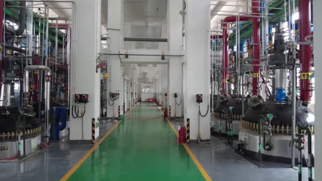 industrial modern power plant interior with modern equipment, large storage steel tanks with metallic pipes near and boilers with cables, pipelines and valves for chemical mixing, modern architecture