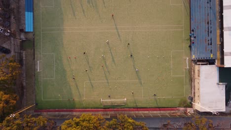 aerial top down moving up view of football players playing the match at the football ground