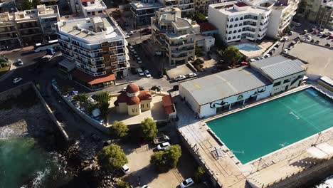 massive pool and apartment buildings of rethymno, aerial orbit view