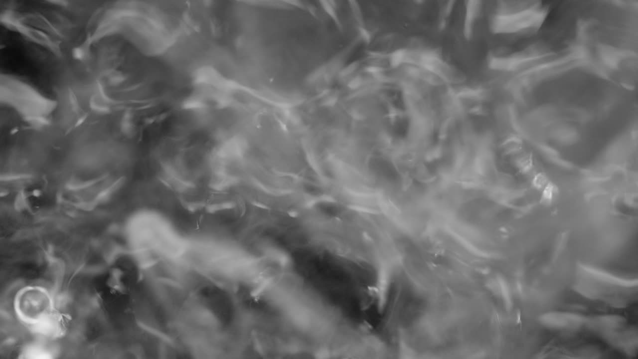 salpicaduras y gotas en la superficie del líquido. abstracto fondo negro vibración del agua. 4k cámara lenta 100 fps, prores 422, 10 bits