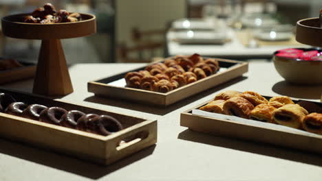 pastry table at a hotel brunch with glamorous cakes and croissants beautifully lit by sun