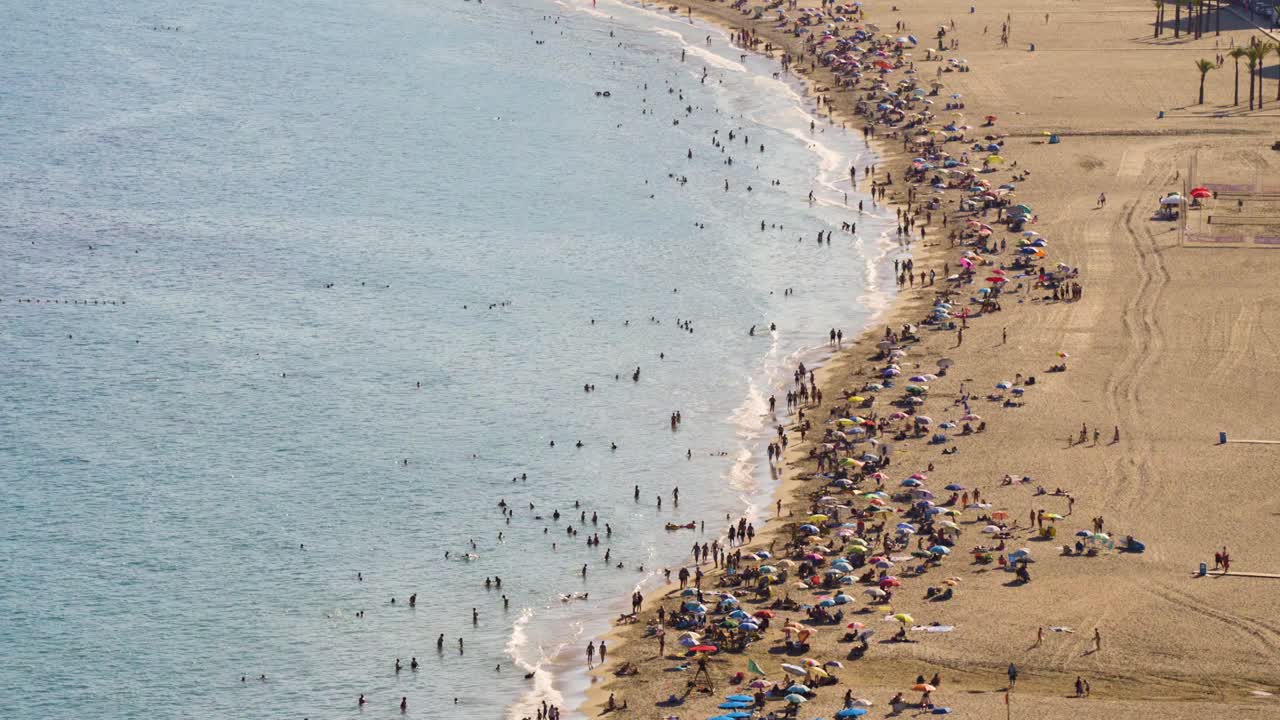 Wide bird&rsquo;s eye view of crowded Mediterranean beach 4K