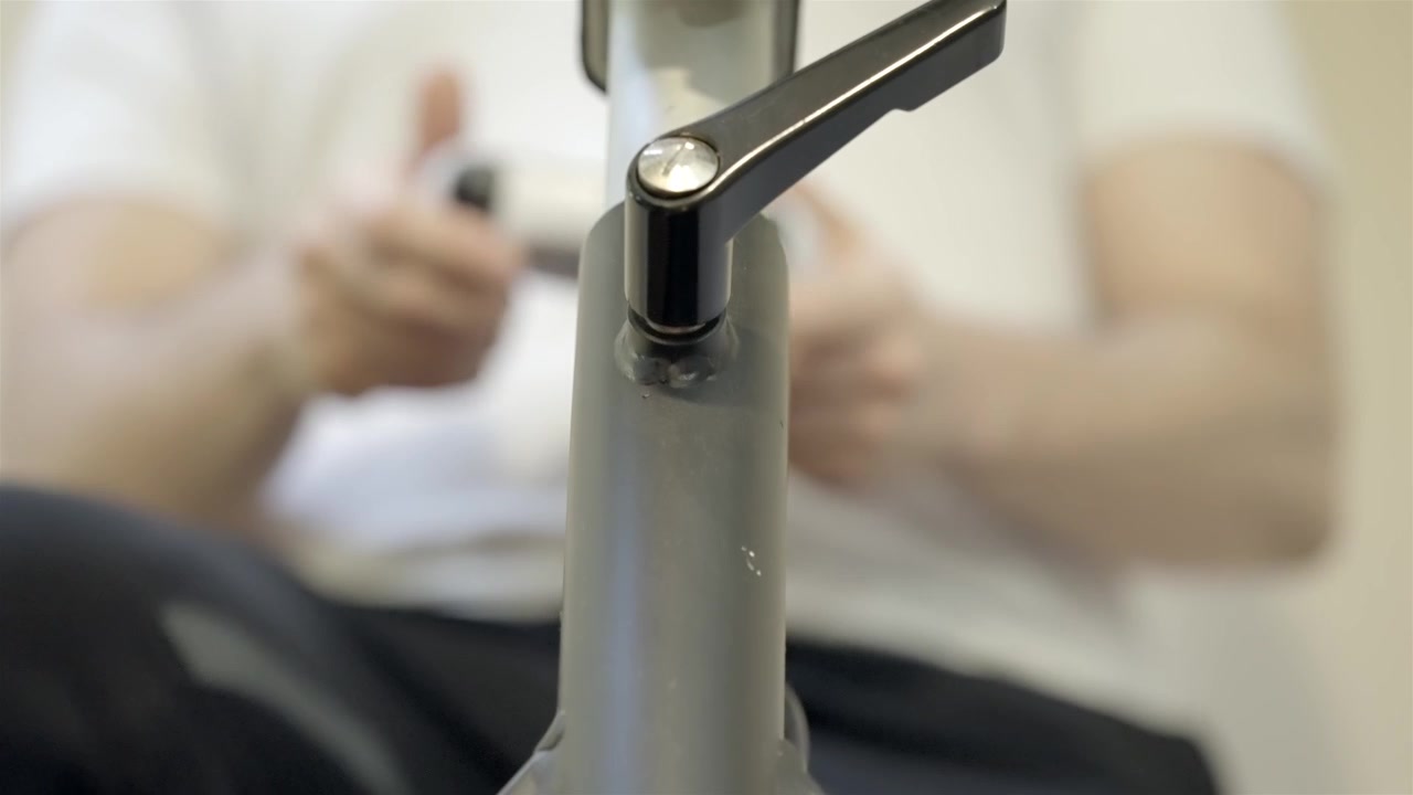 ワークアウトのためにエクササイズバイクを準備するフィットネス愛好家のクローズアップ。