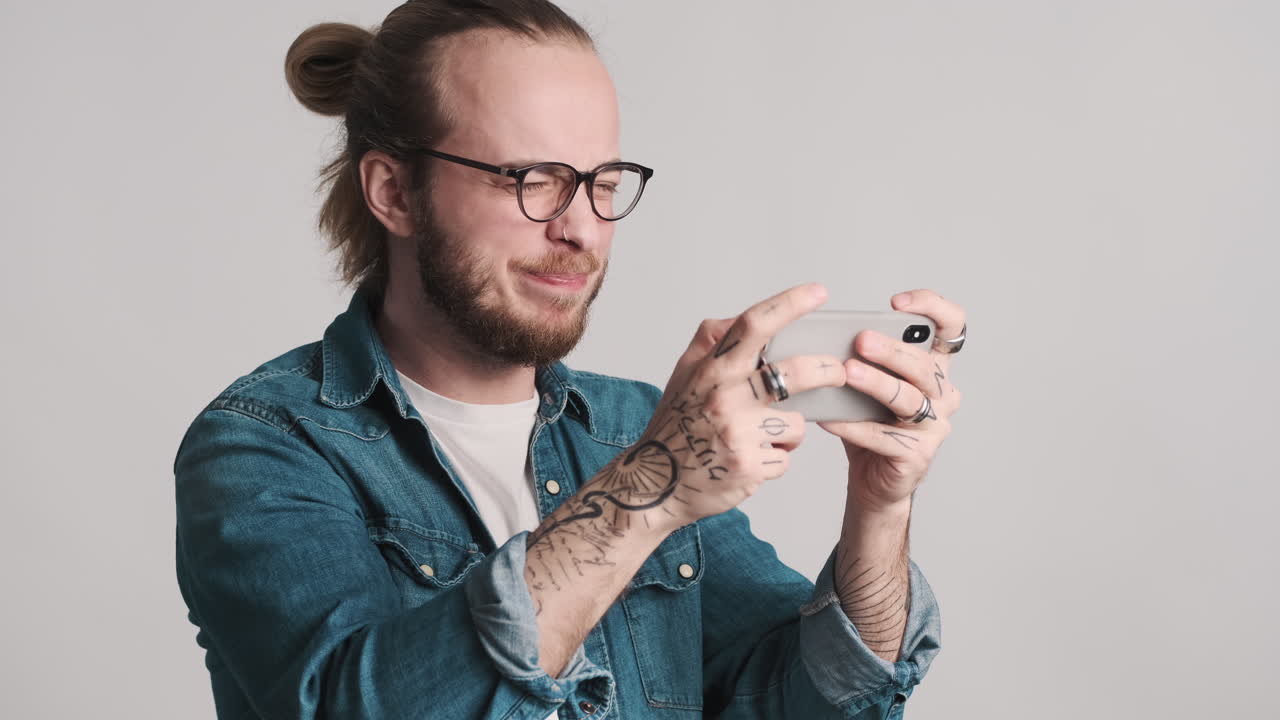 Caucasian young man playing video games on smartphone and loosing.