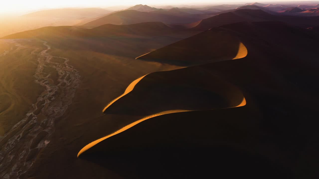 Aerial view around stunning desert dunes with sunset flares in Namibia, Africa
