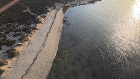 Antena-De-Drones-Moviéndose-Hacia-Atrás-Sobre-La-Costa-Del-Arrecife-Exmouth-Ningaloo-Durante-La-Puesta-De-Sol