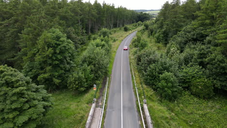 An-electric-Tesla-car-drives-along-road-in-summertime-in-Ireland