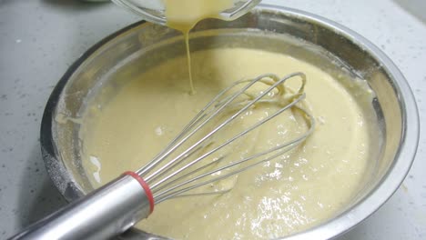 mix the flour and other ingredients until well blended manually. it is the early stage of the baking bread and cakes process. this will take some time to get a good mix.