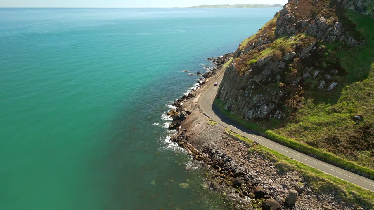 Right-to-left travelling aerial video of the Causeway Coastal Route on a bright and sunny day. Filmed in Ballygally in 4K, 60FPS and with Rec800 color.