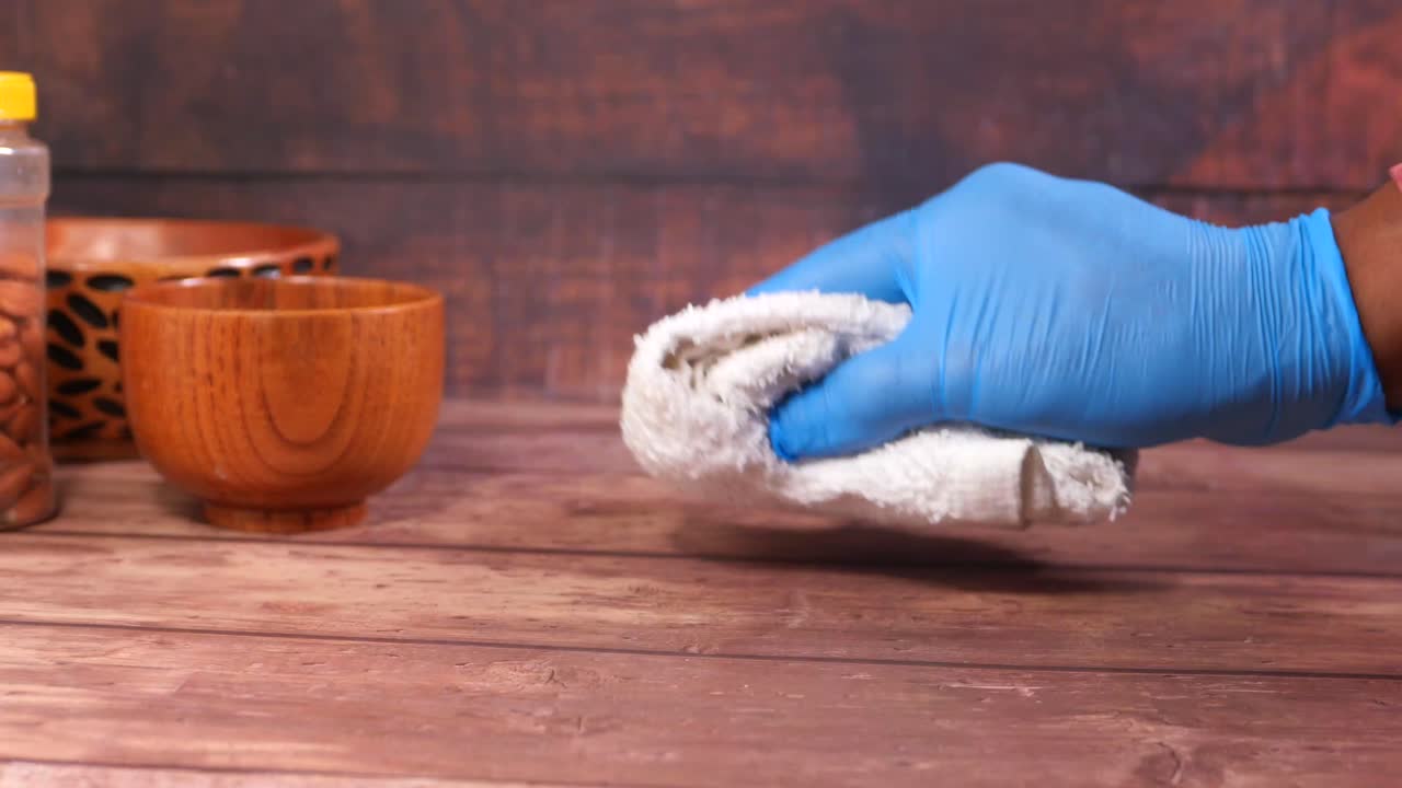 limpiando una mesa de madera con guantes