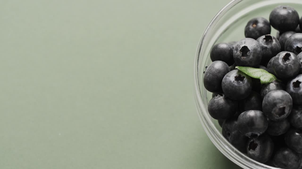 녹색 배경 에 복사 공간 을 가진 블루베리 가 있는 그 ⁇  의 클로즈업 의 마이크로 비디오