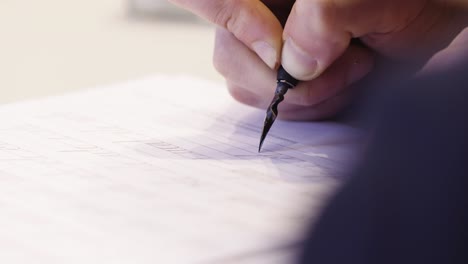 male and writting oldschool black ink pen on the white theet of paper close up slow motion