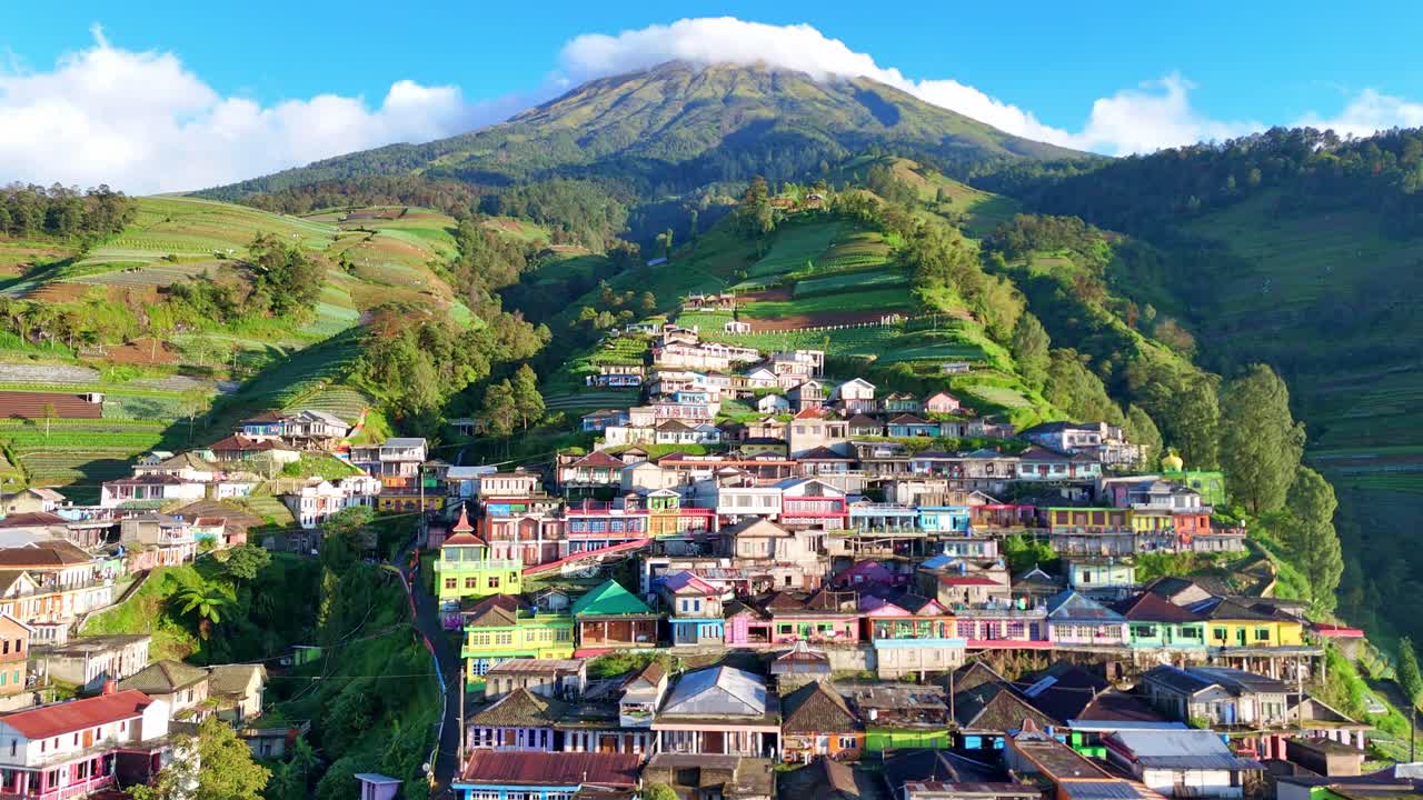 Drone video capturing a scenic hillside town with colorful houses and cultivated terraces in the mountains. Nepal Van Java Village, Mount Sumbing, Indonesia