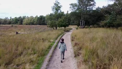toma alta de un chico caminando en la naturaleza con una hermosa vista.