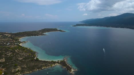 4K-Drone-clip-slowly-moving-backwards-over-a-tropical-island-in-the-bay-of-Vourvourou,-in-Chalkidiki,-northern-Greece