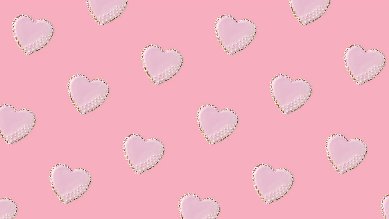 seamless looping animation with pattern of heart shaped cookies decorated by pink glaze on a pastel background, diagonal movement