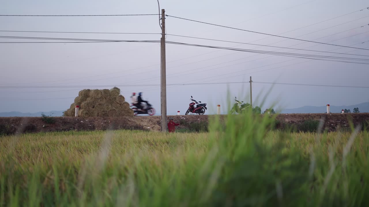 Rural Vietnamese Landscape with Motorbikes and Hay Bales