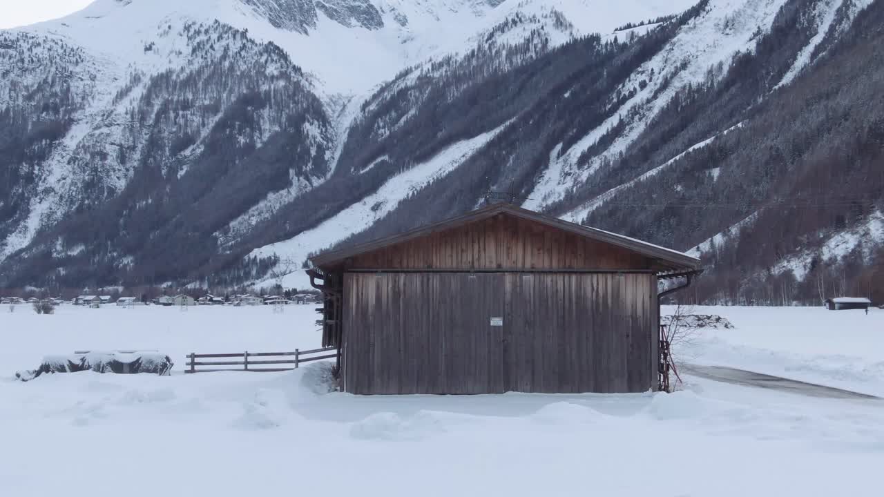 Aerial shot of cabin in the alps at winter. Wooden cabin in snow.cabin in the middle of mountains.