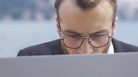 Der-Geschäftsmann-Konzentrierte-Sich-Auf-Seine-Arbeit-Am-Laptop.-Strand.