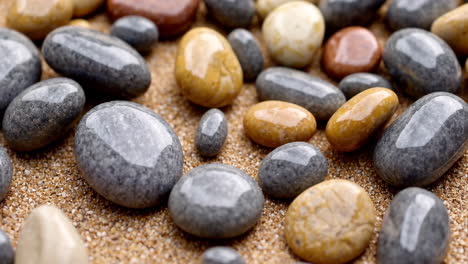 close-up of colorful polished pebbles on sand