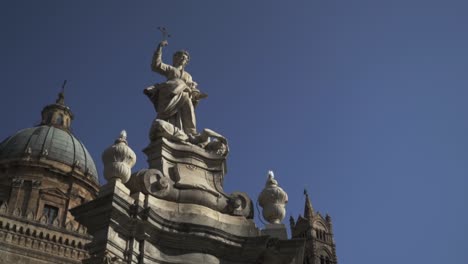 estatua de un santo en lo alto de una estructura monumental en palermo, italia