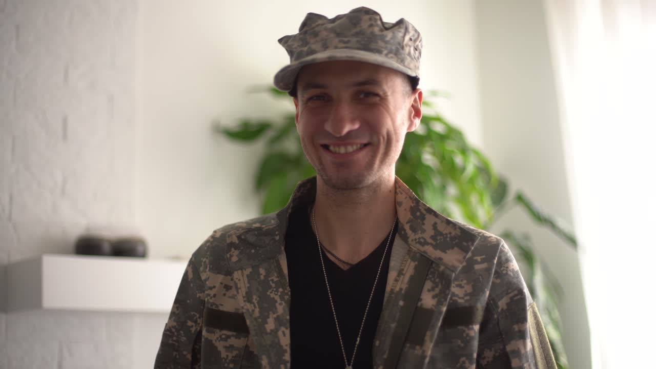 hombre militar con auriculares hablando en cámara lenta mirando a la cámara. video chat pov retrato de un valiente soldado conferenciando en línea de pie en el interior