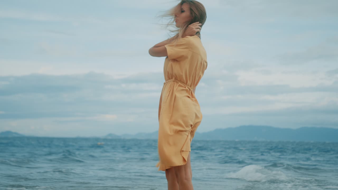Woman in a yellow dress on a windy beach