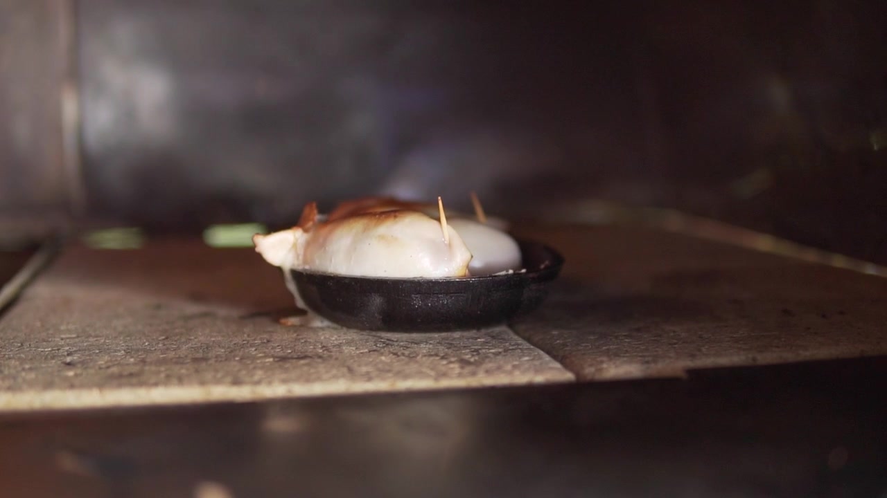 A sizzling close-up shot of stuffed chicken roasting in a cast iron pan inside a rustic oven, with warm lighting highlighting juicy texture.