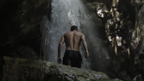 rear view of young man walks towards majestic waterfall, lebanon, day, tilt down