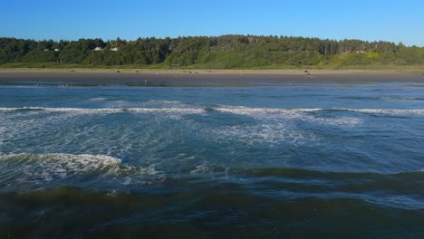 Aerial-shot-gliding-over-ocean-waves-in-the-Pacific-Ocean-and-beach-in-Ocean-Shores