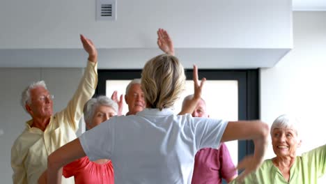 Trainer-assisting-senior-citizens-in-exercising