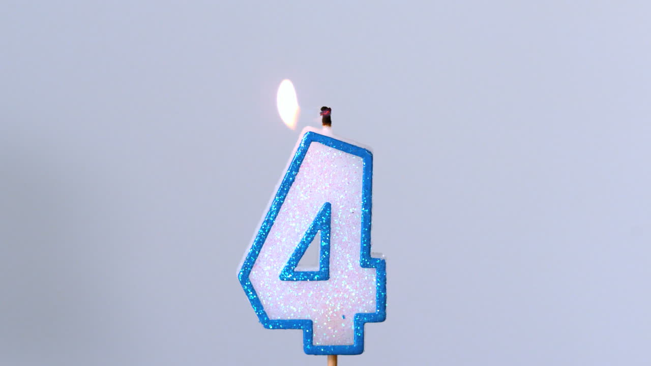 네 개의 생일 불이 파란색 배경에서 박이고 꺼지고 있습니다.