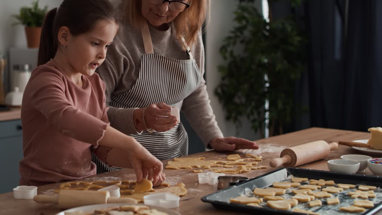 Caucasian girl baking homemade cookies with grandmother