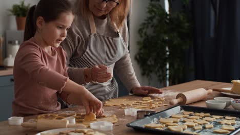 caucasian girl baking homemade cookies with grandmother